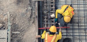 Aerial of Construction Workers in yellow working with gravel